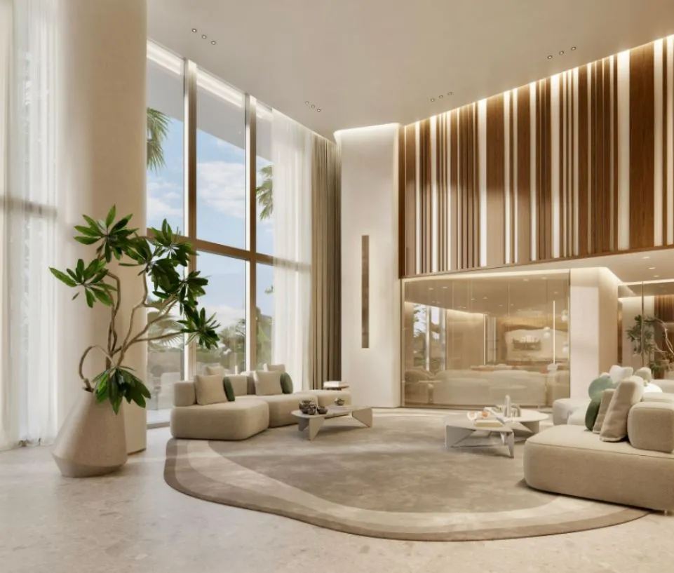 El lobby lounge de doble altura de Origin: una jardinera escultórica de piedra, sofás bajos en tonos arena sobre una alfombra curva y una pared de listones de madera iluminada por detrás.