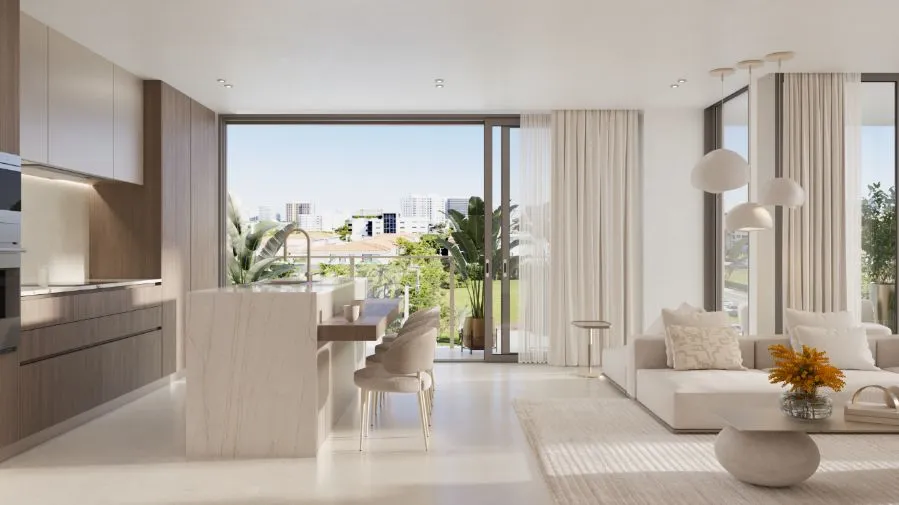 Un espacio de Origin de planta abierta entre sala y cocina, con isla de mármol, sofá seccional bajo y cortinas ligeras recogidas frente a un balcón con plantas.